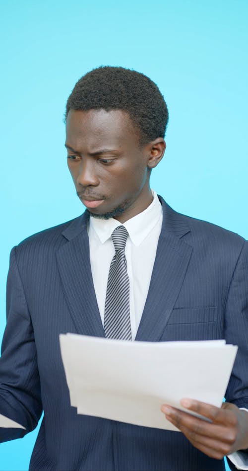 Man Wearing Corporate Attire Looking at Papers