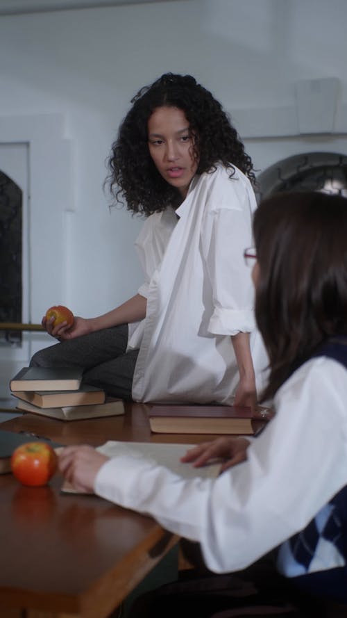 A Woman Talking to her Friend while Sitting at a Table