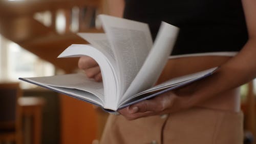 Close up of a Person Flipping Pages on a Book