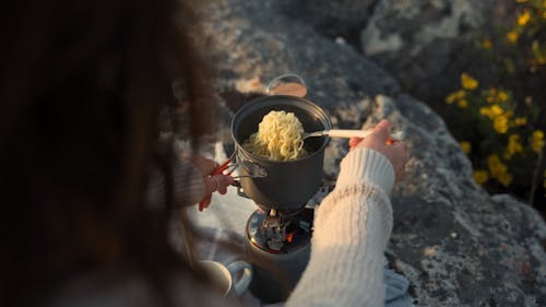 Woman Mixing the Noodles on the Pot 