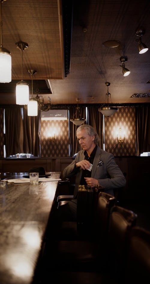 Man Wearing Suit Leaving Money at the Bar Counter
