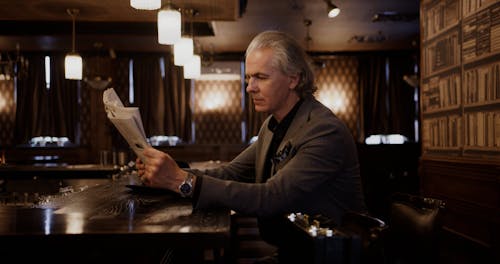 An Elderly Man Reading a Newspaper