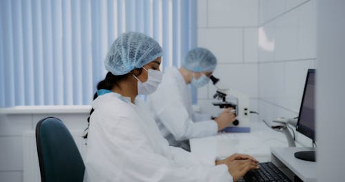 A Man and Woman Working at the Lab while Wearing Face Mask