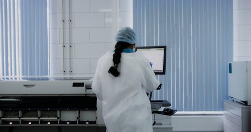 Back View of a Medical Technologist Using an Immunoassay Analyzer