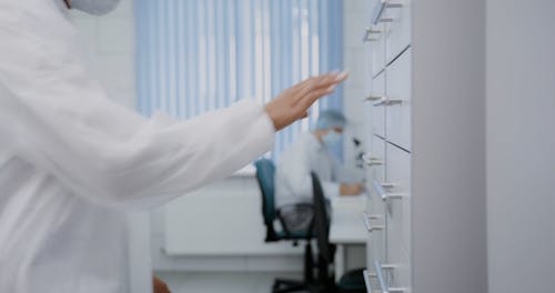 A Woman Opening a Drawer while Looking for a Sample