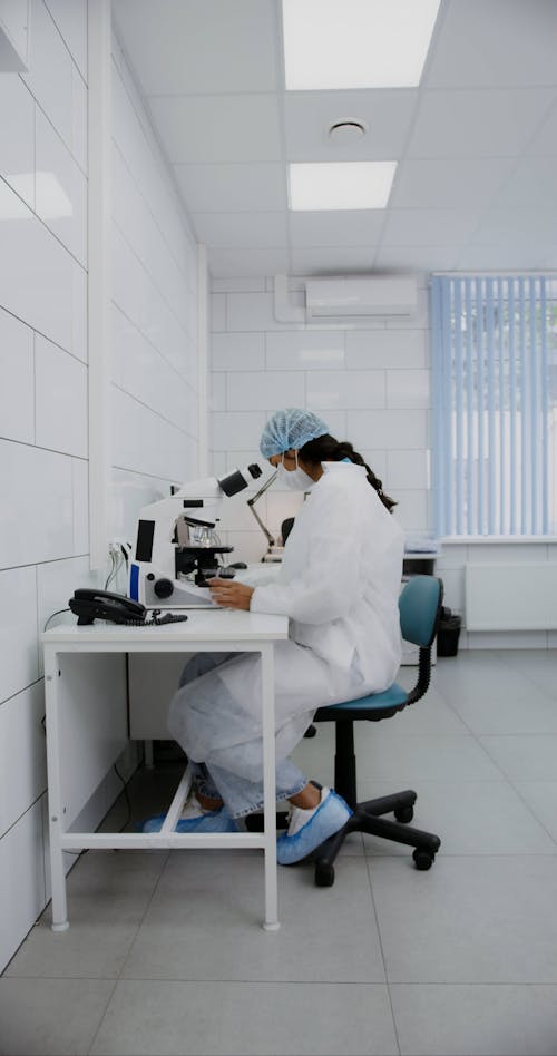 A Medical Practitioner Looking Through a Microscope