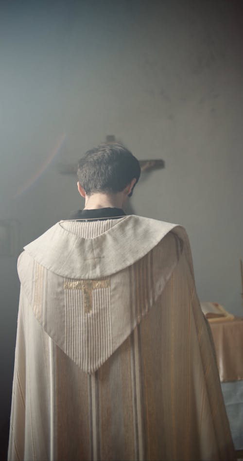 Man Holding Rosary While Praying at the Church