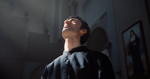 Man Holding a Bible While Praying