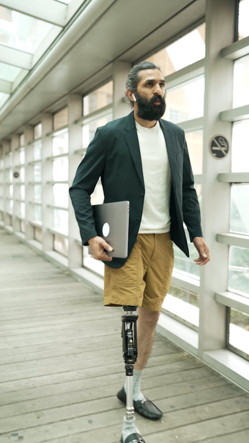 Businessman with Prosthetic Leg carrying Laptop