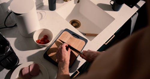 A Person Slicing Cherry Tomatoes