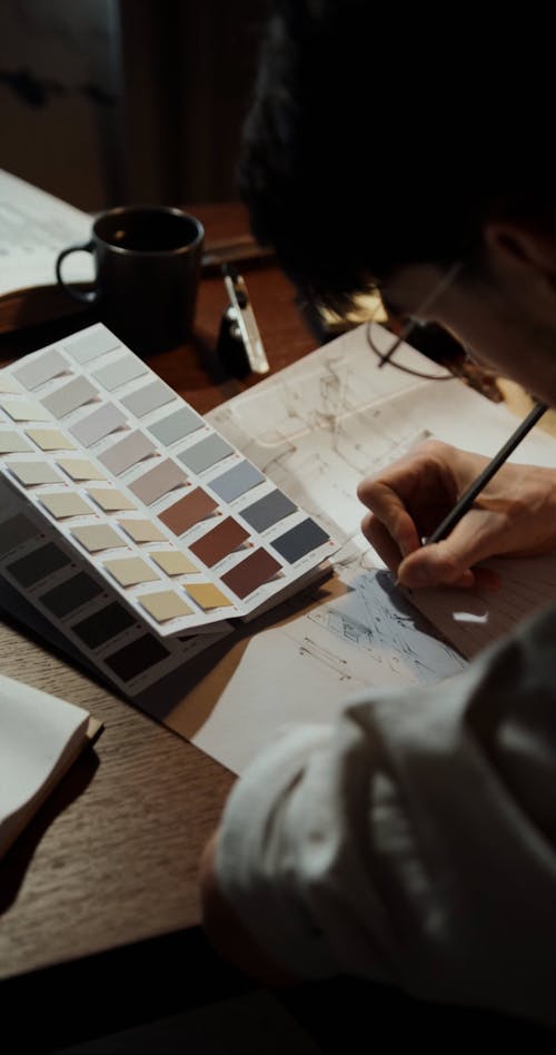 A Man Picking Colors while Writing on Paper