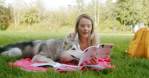 A Woman Lying Down on the Park with Her Dog