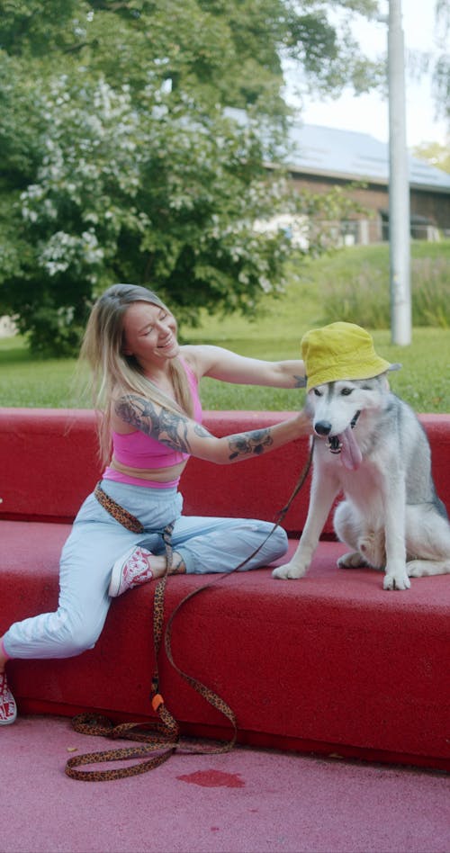 Woman Petting her Dog while Sitting on an Outdoor Sofa