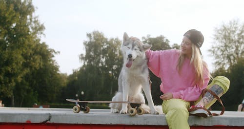 A Skater Petting Her Dog 
