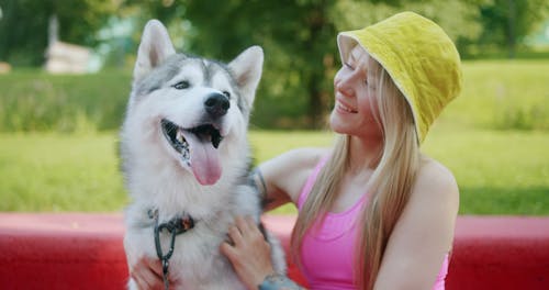 A Woman Wearing a Bucket Hat while Petting Her Dog