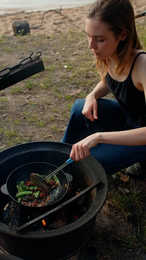 Woman Cooking Food while in Camping