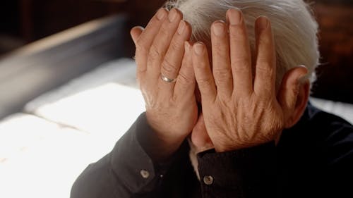 An Elderly Man Touching his Face