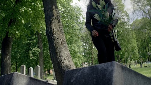 Woman Putting Flowers on a Grave