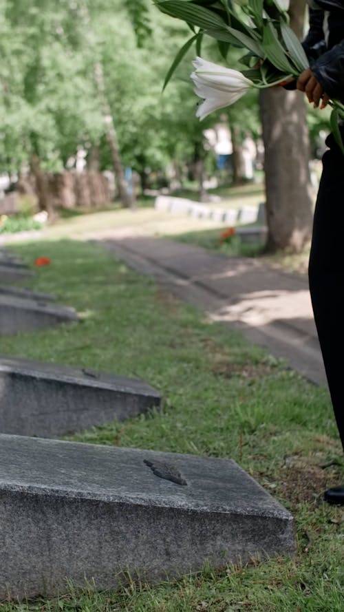 Woman Putting Flowers in a Grave