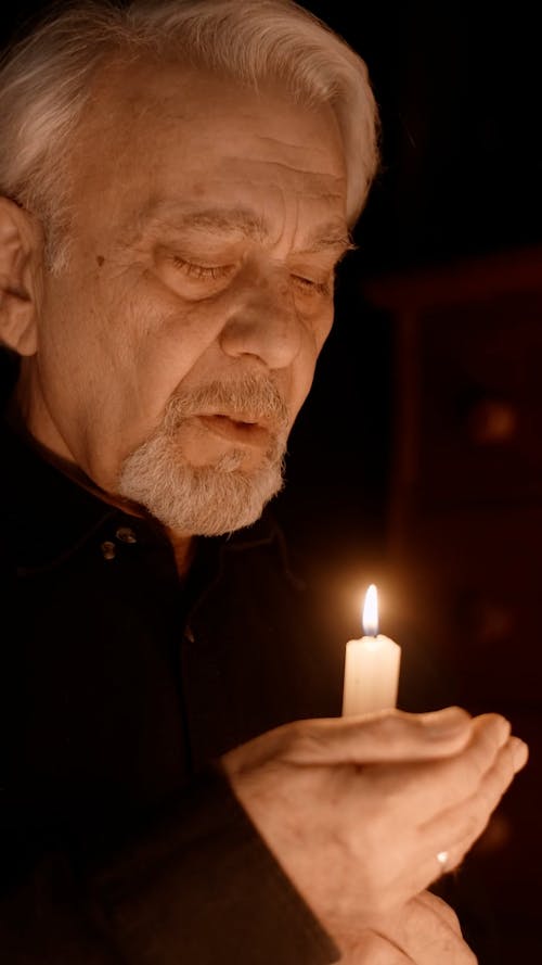 Elderly Man Blowing Out a Candle