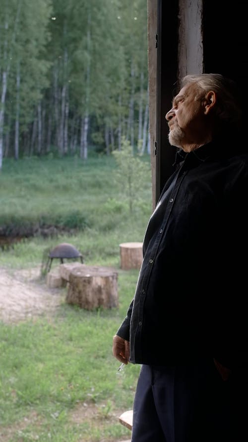 An Elderly Man Standing by an Open Door