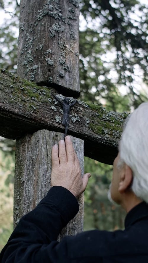 Close Up Video of an Elderly Man Touching a Cross