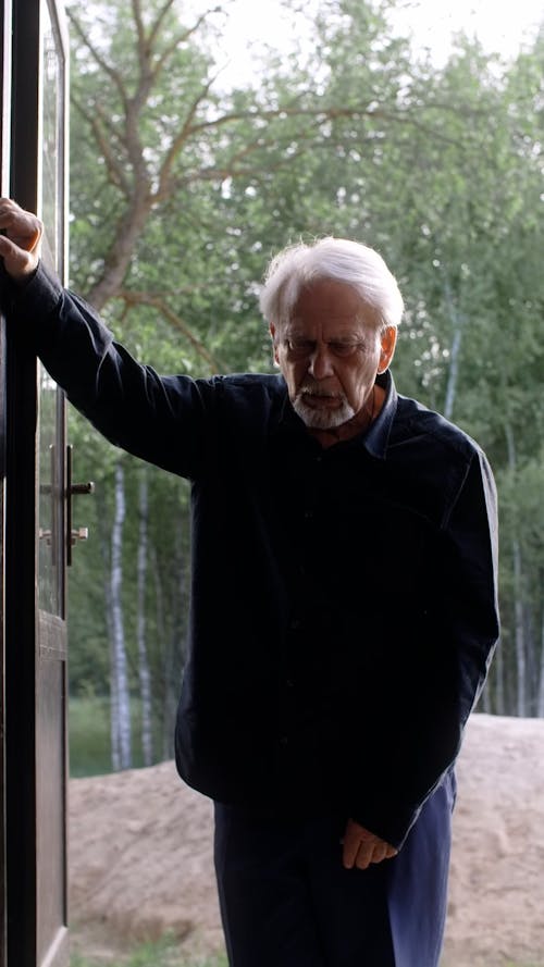 An Elderly Man Leaning by a Doorway