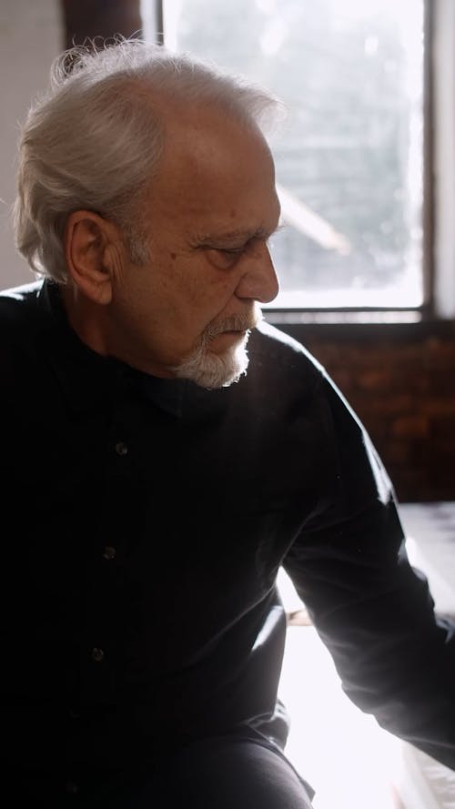 Elderly Man Sitting on Bed