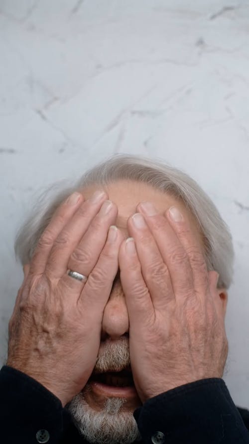 Elderly Man Holding his Face