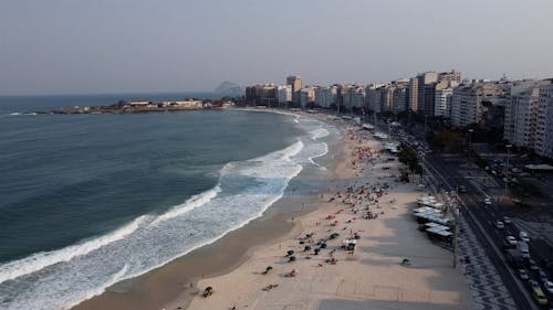 Drone shot of beach, street and city buildings