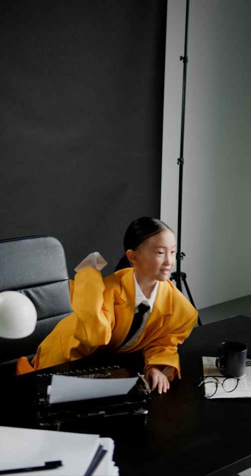 A Girl Wearing Yellow Blazer Throwing a Paper Plane