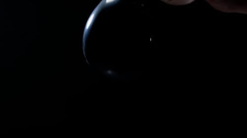 Person Popping a Black Water Balloon