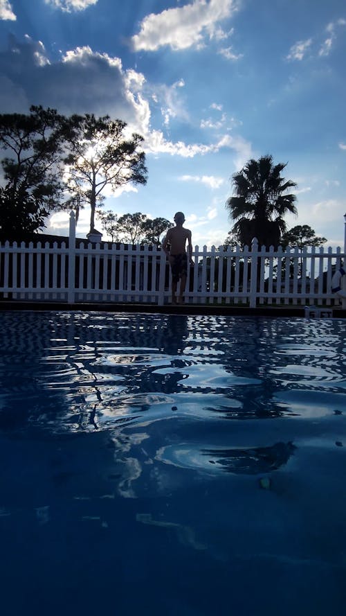 A Young Boy Jumping Into the Swimming Pool