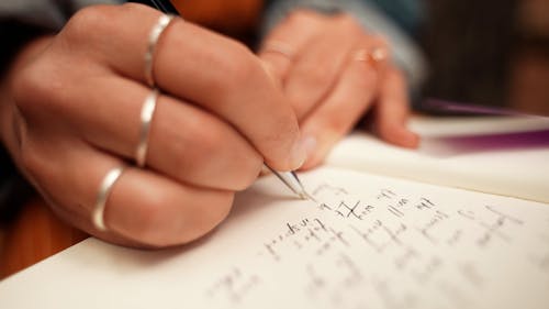 A Person Writing on a Journal