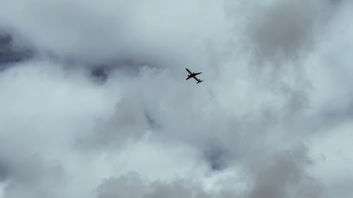 An Airplane Flying in a Cloudy Sky