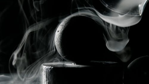 Close-Up Shot of a Black Ball Surrounded by Smoke