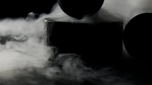 Close-Up Shot of Black Balls Surrounded by Smoke