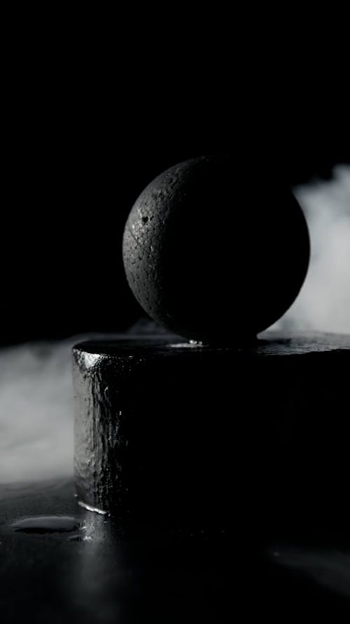 Close-Up Shot of a Black Ball Surrounded by Smoke