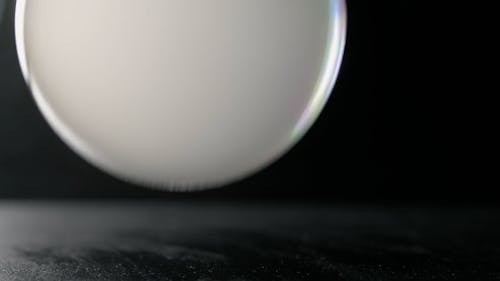 A White Bubble Bounce on a Black Surface then Pops Up