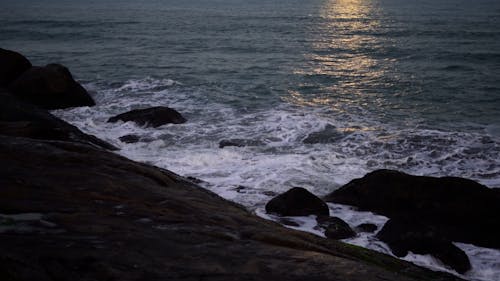 Waves splashing on seashore at dusk