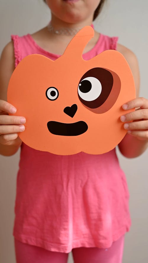 Girl holding pumpkin like decoration