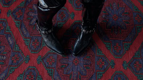 Feet of person dancing in black leather shoes 