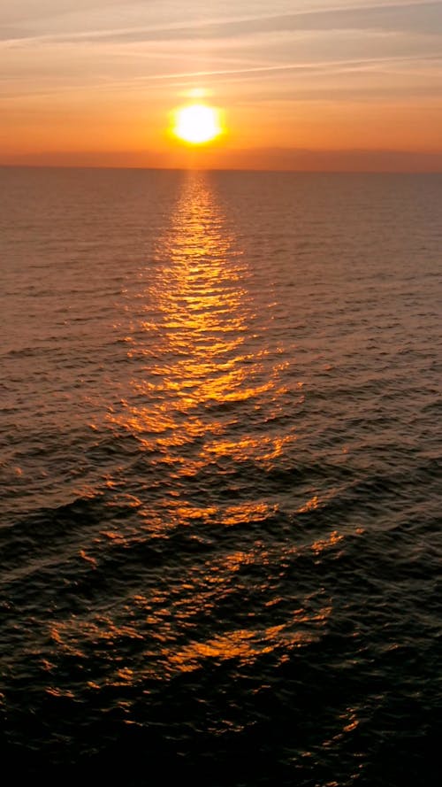 Sea under orange sky at sunset