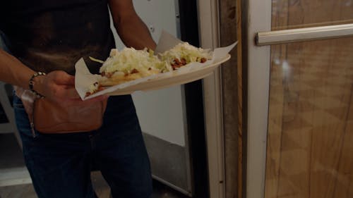 Waiter carrying tacos in Latino restaurant