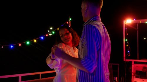 A Couple Holding Hands while Dancing
