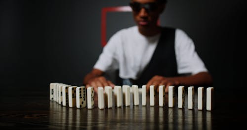 Man placing domino blocks on table