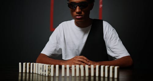 A Man Checking Dominoes on the Table