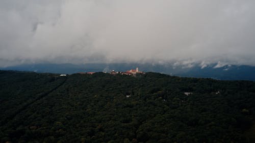 White clouds over forest on hills