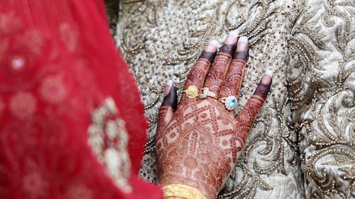 Hand of woman with henna tattoo and rings