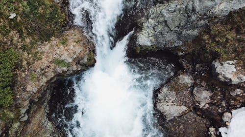 Aerial view of waterfall, forest and snow